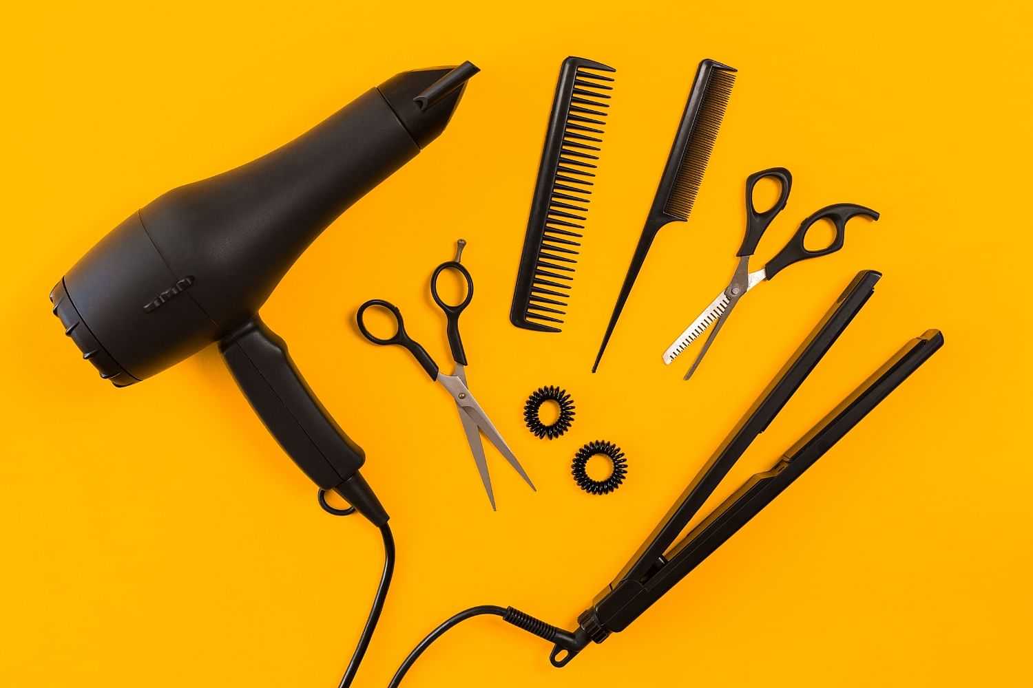 Hair styling tools arranged on a yellow background.